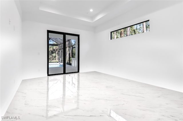 491 9th St SW, Naples, FL 34117 - spare room featuring a raised ceiling, marble finish flooring, and recessed lighting