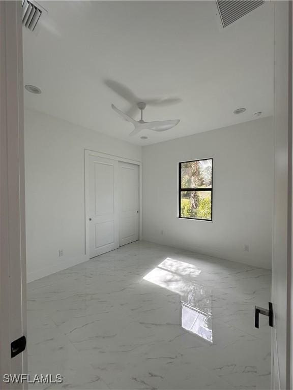 491 9th St SW, Naples, FL 34117 - unfurnished bedroom featuring marble finish flooring, a closet, and ceiling fan