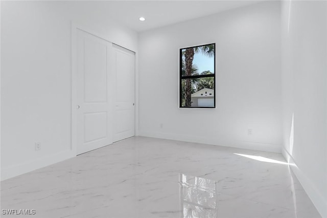 491 9th St SW, Naples, FL 34117 - unfurnished bedroom with light marble finish floors, recessed lighting, and a closet