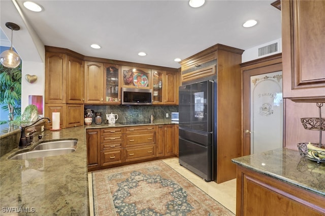 1920 Virginia Ave Unit 1102, Fort Myers, FL 33901 - kitchen featuring freestanding refrigerator, stainless steel microwave, stone counters, brown cabinets, and inlaid floor details