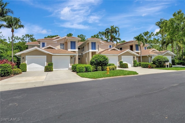 857 Carrick Bend Cir Unit 101, Naples, FL 34110 - view of front of home featuring driveway, stucco siding, a garage, and a tile roof