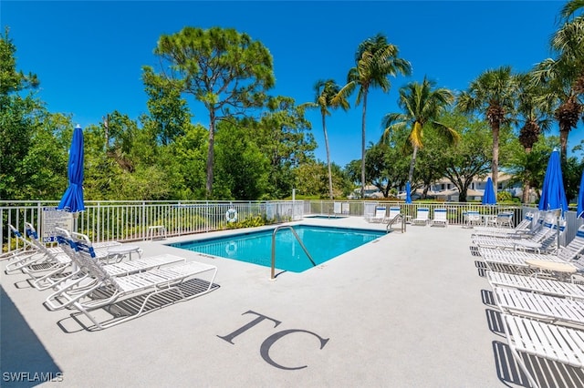 857 Carrick Bend Cir Unit 101, Naples, FL 34110 - community pool with a patio and view of wooded area