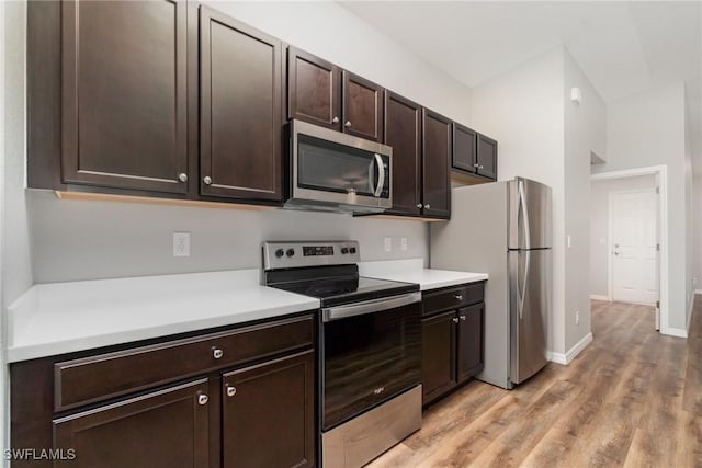 40 Ponoka St, Port Charlotte, FL 33954 - kitchen with stainless steel appliances, light countertops, dark brown cabinetry, and light wood-style flooring