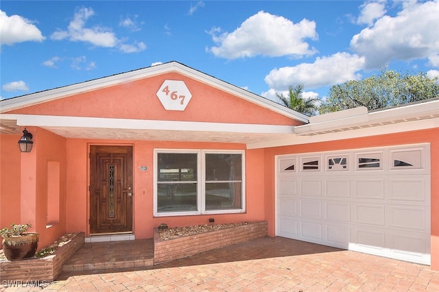 467 Stipe St, North Fort Myers, FL 33903 - view of front of home with stucco siding, a garage, and decorative driveway