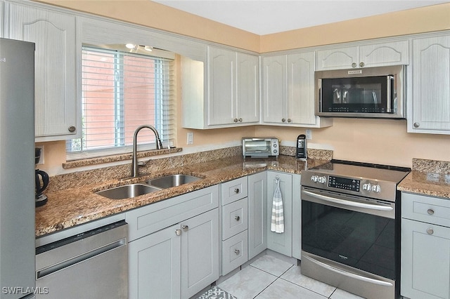 467 Stipe St, North Fort Myers, FL 33903 - kitchen featuring stainless steel appliances, stone counters, light tile patterned flooring, and white cabinets