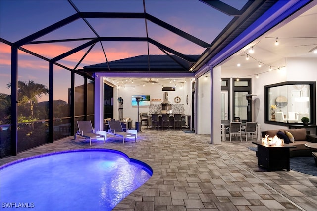 11699 Caleri Ct, Fort Myers, FL 33913 - pool at dusk with a fire pit, a patio area, a lanai, and an outdoor pool