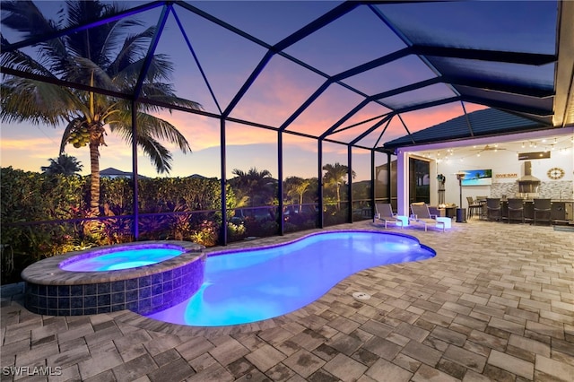 11699 Caleri Ct, Fort Myers, FL 33913 - pool at dusk featuring a patio area, a pool with connected hot tub, and a lanai
