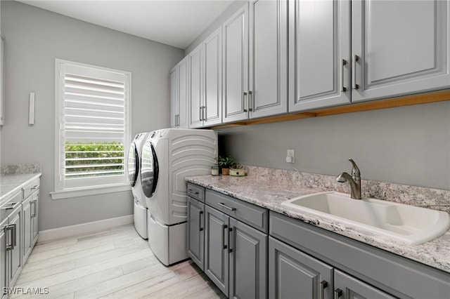 11699 Caleri Ct, Fort Myers, FL 33913 - laundry room with separate washer and dryer, cabinet space, and light wood-style flooring