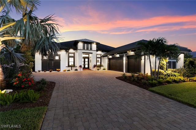 11699 Caleri Ct, Fort Myers, FL 33913 - view of front facade with french doors, decorative driveway, an attached garage, and stucco siding