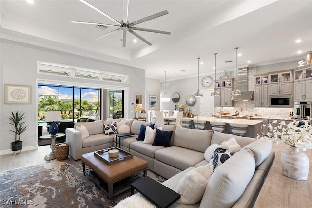 11699 Caleri Ct, Fort Myers, FL 33913 - living area with a raised ceiling, ceiling fan, wood finished floors, recessed lighting, and ornamental molding