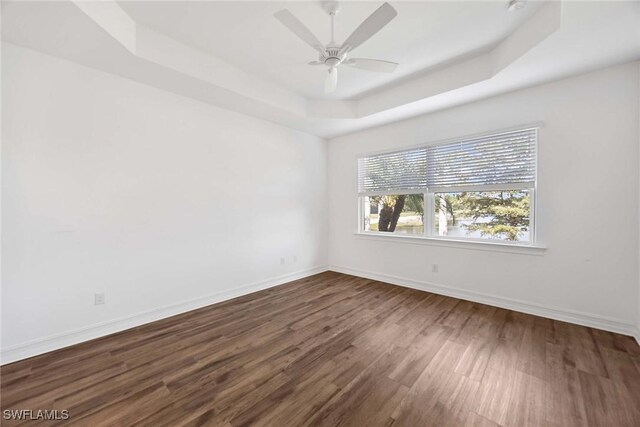 14601 Tropical Dr, Naples, FL 34114 - unfurnished room featuring a tray ceiling, dark wood finished floors, and a ceiling fan