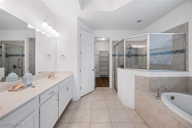 14601 Tropical Dr, Naples, FL 34114 - full bath with double vanity, a walk in closet, a stall shower, a bath, and tile patterned flooring
