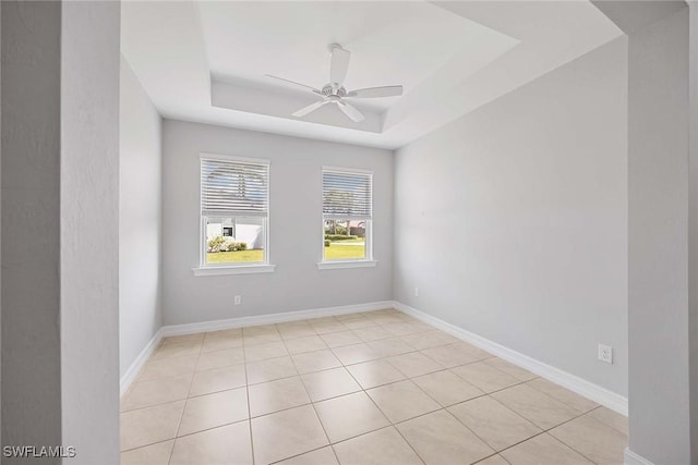 14601 Tropical Dr, Naples, FL 34114 - spare room featuring a tray ceiling, ceiling fan, and light tile patterned flooring