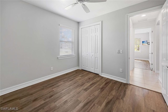 14601 Tropical Dr, Naples, FL 34114 - unfurnished bedroom with wood finished floors, multiple windows, a closet, and ceiling fan