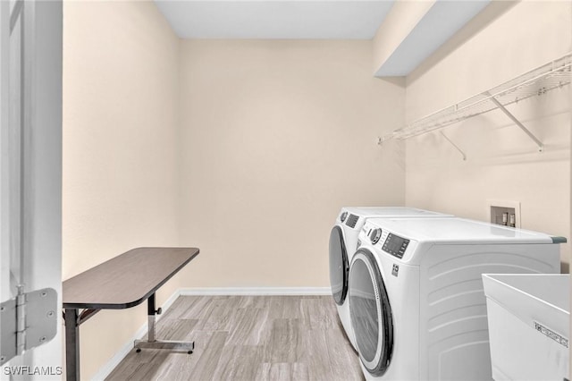 6027 Acorn Cir, Labelle, FL 33935 - laundry room featuring washer and clothes dryer and light wood-style flooring
