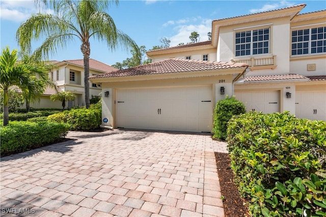 26425 Lucky Stone Rd Unit 201, Bonita Springs, FL 34135 - mediterranean / spanish-style home with stucco siding, a tiled roof, and driveway