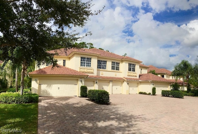 26425 Lucky Stone Rd Unit 201, Bonita Springs, FL 34135 - mediterranean / spanish-style home featuring stucco siding, a tile roof, a garage, and driveway
