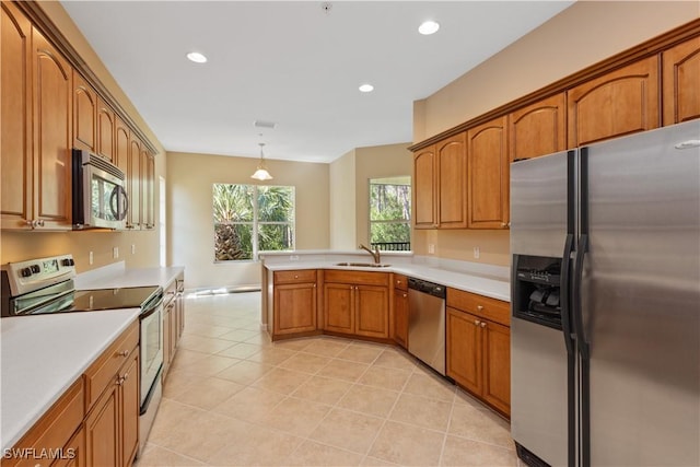 26425 Lucky Stone Rd Unit 201, Bonita Springs, FL 34135 - kitchen featuring appliances with stainless steel finishes, a peninsula, brown cabinets, light countertops, and recessed lighting
