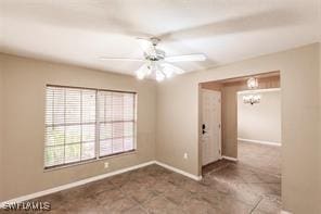 4238 Golfair Ln, North Port, FL 34288 - spare room featuring ceiling fan, a chandelier, and tile patterned floors