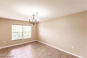 4238 Golfair Ln, North Port, FL 34288 - tiled spare room featuring a chandelier and baseboards