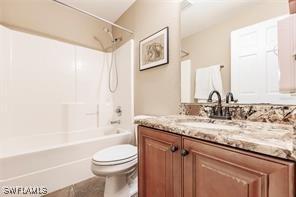 4238 Golfair Ln, North Port, FL 34288 - bathroom with vanity, shower / bathtub combination, and tile patterned flooring