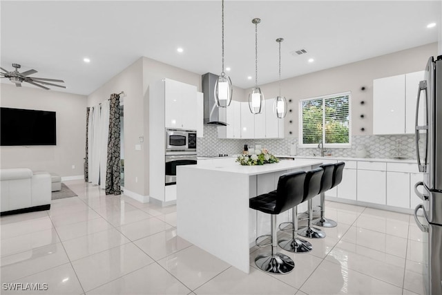1806 41st St SW, Naples, FL 34116 - kitchen featuring appliances with stainless steel finishes, wall chimney range hood, open floor plan, white cabinetry, and recessed lighting