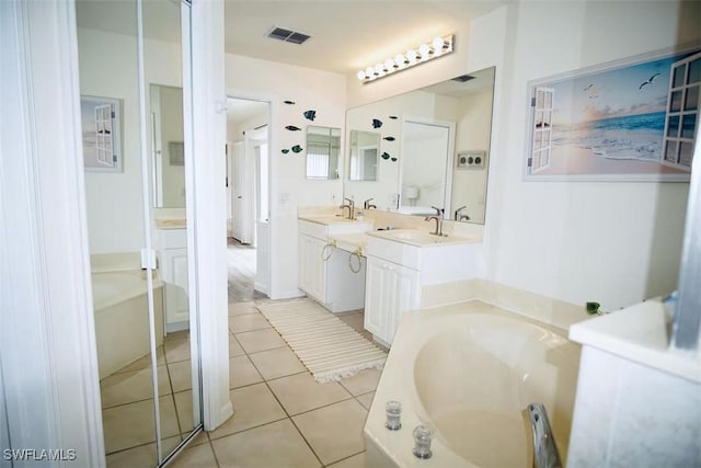 1958 Terrazzo Ln, Naples, FL 34104 - bathroom with a garden tub, double vanity, and tile patterned flooring
