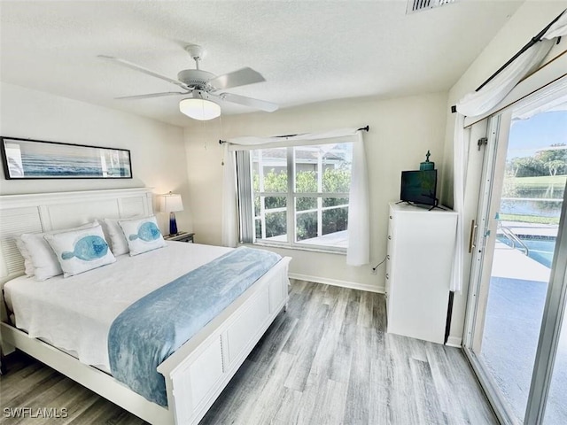 1958 Terrazzo Ln, Naples, FL 34104 - bedroom featuring wood finished floors, access to exterior, multiple windows, and a textured ceiling