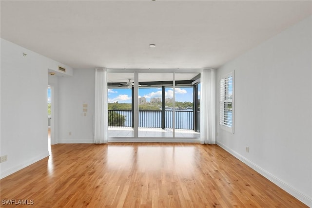 420 Cove Tower Dr Unit 304, Naples, FL 34110 - spare room featuring light wood-style floors, ceiling fan, and a water view