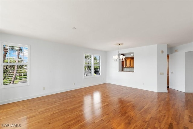 420 Cove Tower Dr Unit 304, Naples, FL 34110 - unfurnished room with a chandelier and light wood-style floors