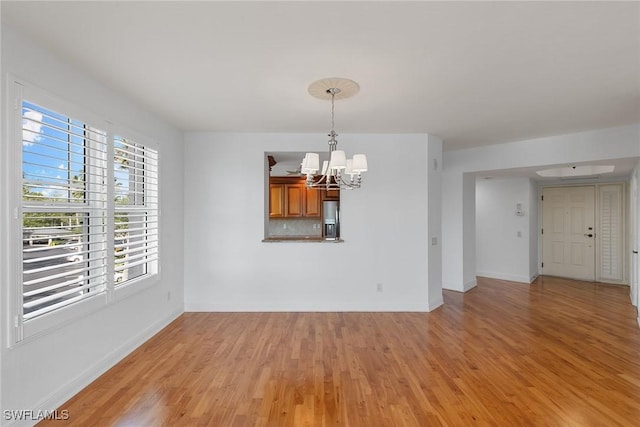 420 Cove Tower Dr Unit 304, Naples, FL 34110 - spare room with a chandelier and light wood finished floors