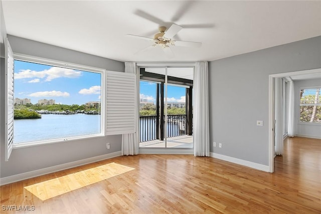 420 Cove Tower Dr Unit 304, Naples, FL 34110 - unfurnished room featuring a ceiling fan, wood finished floors, and a water view