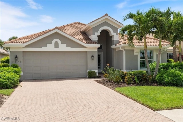 9245 Independence Way, Fort Myers, FL 33913 - mediterranean / spanish home with an attached garage, decorative driveway, stucco siding, and a tile roof