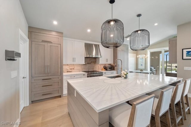 9245 Independence Way, Fort Myers, FL 33913 - kitchen with wall chimney range hood, decorative backsplash, a large island with sink, recessed lighting, and electric stove