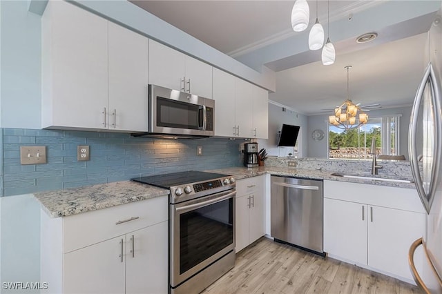 7625 Arbor Lakes Ct Unit 315, Naples, FL 34112 - kitchen featuring appliances with stainless steel finishes, crown molding, light wood-style flooring, decorative backsplash, and a chandelier