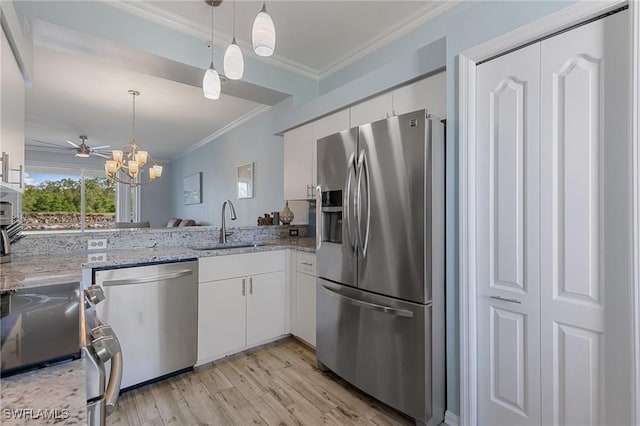 7625 Arbor Lakes Ct Unit 315, Naples, FL 34112 - kitchen with appliances with stainless steel finishes, crown molding, white cabinetry, light wood-style flooring, and pendant lighting