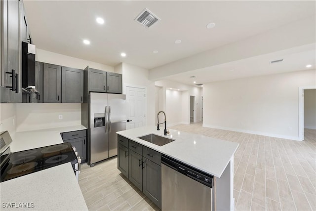2701 53rd St W, Lehigh Acres, FL 33971 - kitchen featuring stainless steel appliances, light countertops, light wood finished floors, open floor plan, and recessed lighting