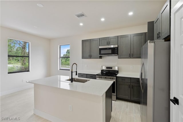 2703 54th St W, Lehigh Acres, FL 33971 - kitchen with appliances with stainless steel finishes, recessed lighting, light countertops, and a center island with sink