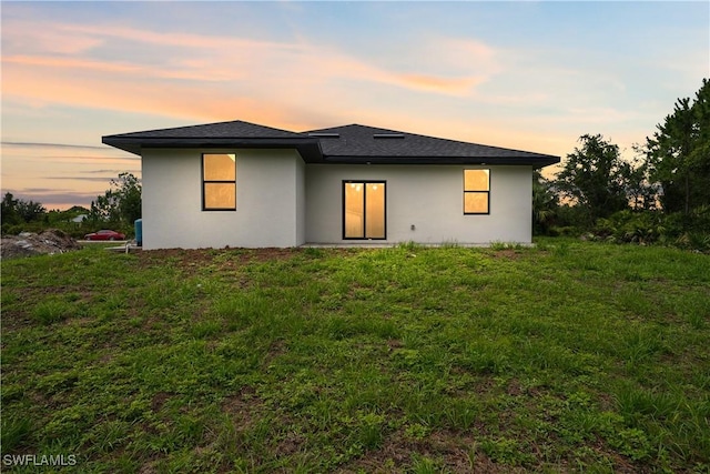 2703 54th St W, Lehigh Acres, FL 33971 - back of house at dusk featuring stucco siding