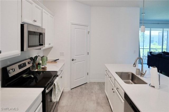 2445 Orchard St, Naples, FL 34120 - kitchen featuring stainless steel appliances, white cabinetry, light countertops, and open floor plan