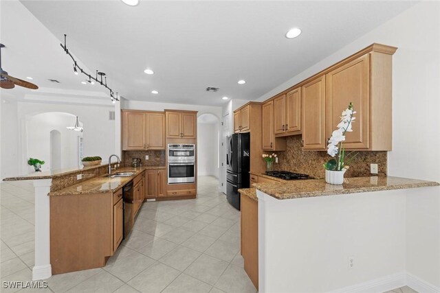 19793 Casa Verde Way, Estero, FL 33967 - kitchen with a peninsula, arched walkways, black appliances, light stone counters, and recessed lighting