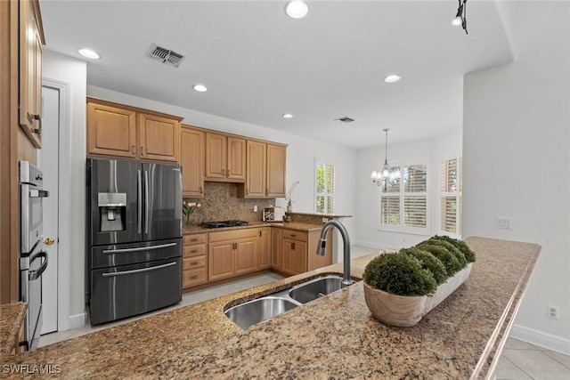 19793 Casa Verde Way, Estero, FL 33967 - kitchen with stainless steel appliances, light stone countertops, a chandelier, recessed lighting, and decorative backsplash
