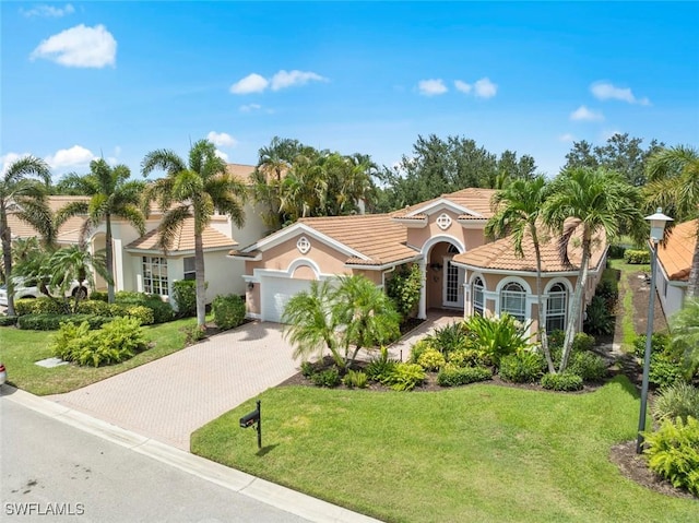 19793 Casa Verde Way, Estero, FL 33967 - mediterranean / spanish-style house with decorative driveway, a front lawn, an attached garage, and stucco siding