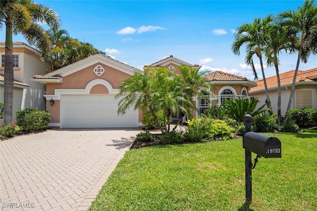 19793 Casa Verde Way, Estero, FL 33967 - mediterranean / spanish home with a garage, stucco siding, a front yard, and decorative driveway
