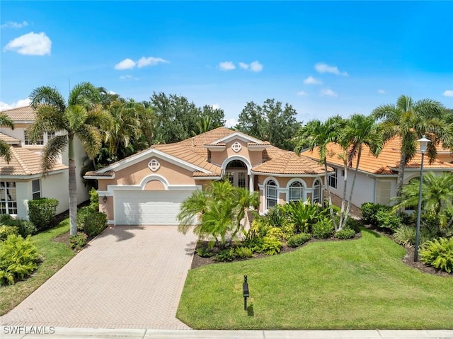 19793 Casa Verde Way, Estero, FL 33967 - mediterranean / spanish home featuring decorative driveway, a garage, a front lawn, stucco siding, and a tile roof