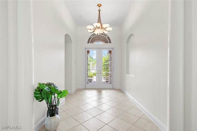 19793 Casa Verde Way, Estero, FL 33967 - entryway featuring arched walkways, a chandelier, french doors, and light tile patterned flooring