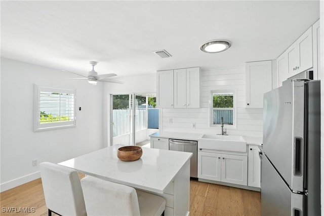 1324 Highlands Dr, Naples, FL 34103 - kitchen featuring appliances with stainless steel finishes, plenty of natural light, white cabinets, and light wood finished floors