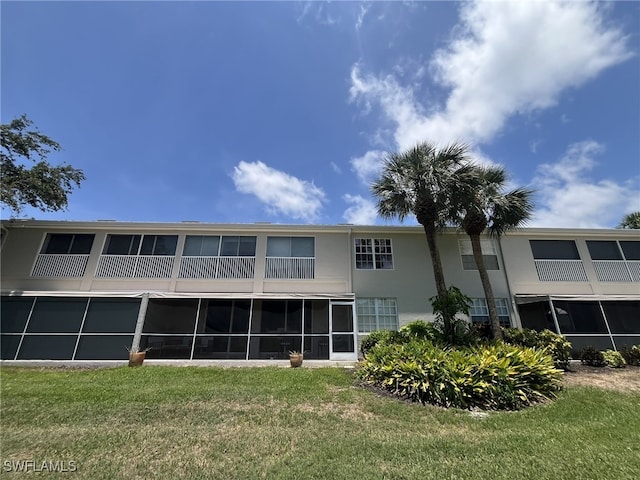 13020 Hamilton Harbour Dr Unit I3, Naples, FL 34110 - rear view of property featuring a lawn, stucco siding, and a sunroom