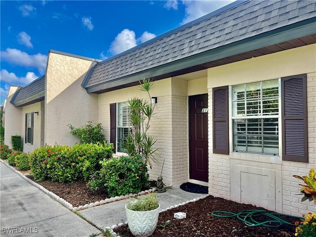 6300 S Pointe Blvd Unit 312, Fort Myers, FL 33919 - doorway to property with a shingled roof, mansard roof, and brick siding