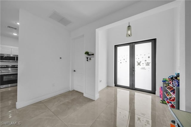 2607 4th St SW, Lehigh Acres, FL 33976 - foyer with french doors and light tile patterned flooring